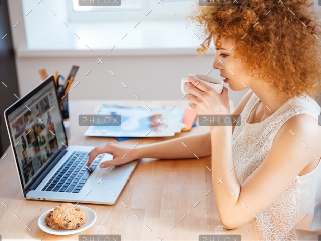demo-attachment-410-woman-photographer-drinking-coffee-and-working-PJNBP6U